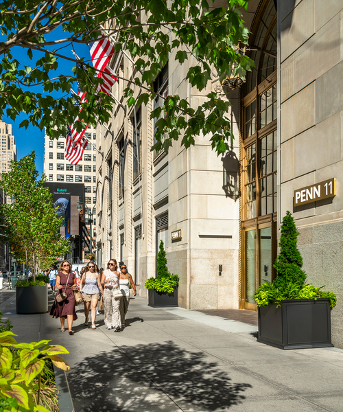people walk in front of penn 11 on the street